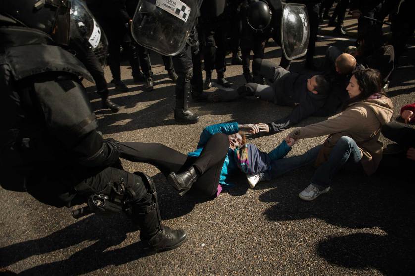 Riot Police remove housing rights activists as they tries to stop Luisa Gracia Gonzalez and her family's eviction and the demolition of their house by a forced expropriation in Madrid, Spain, Friday, Feb. 27, 2015. Madrid authorities say 11 people were arrested after several dozen protesters clashed with police who were carrying out an eviction order. A city spokeswoman said seven people were arrested for throwing gasoline at police officers, though she said the fuel was not set alight. The official spoke on condition of anonymity in keeping with city hall rules. Evictions in Spain have soared since the country's economic crisis began in 2008 and increasing numbers of people were unable to meet mortgage payments. Protesters regularly try to prevent evictions, but Friday's clash was particularly tense after a campaign to keep the family in its home. The house was expropriated for demolition as part of new urban project. Some 30 protesters tried to stop it, accusing authorities of real estate speculation. (AP Photo/Andres Kudacki)