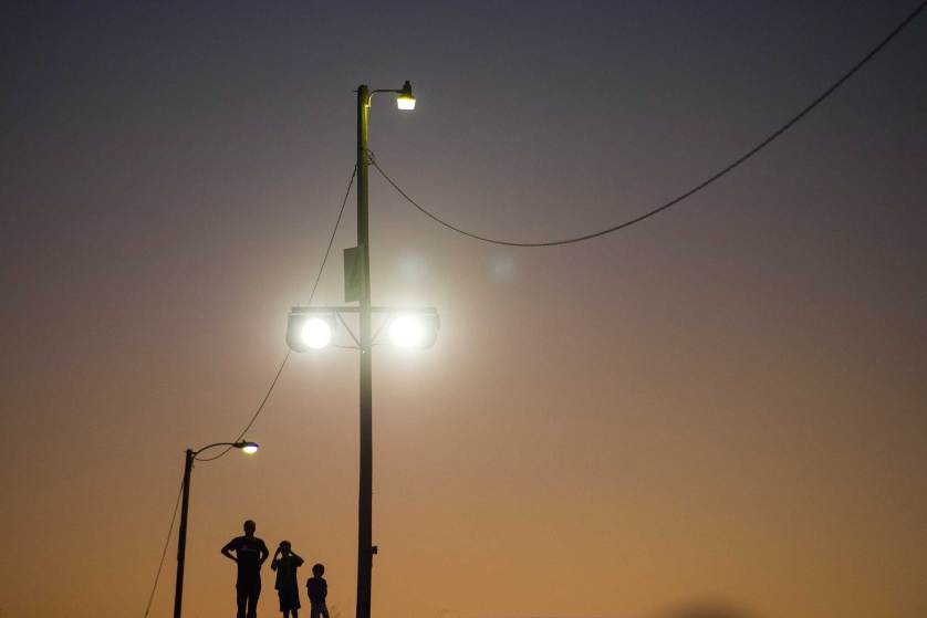 A man and two boys stand on a hillside and wait for Democratic presidential candidate Sen. Bernie Sanders to address supporters during a campaign rally at Prince William Fairground in Manassas, Va., Monday, Sept. 14, 2015. (AP Photo/Cliff Owen)