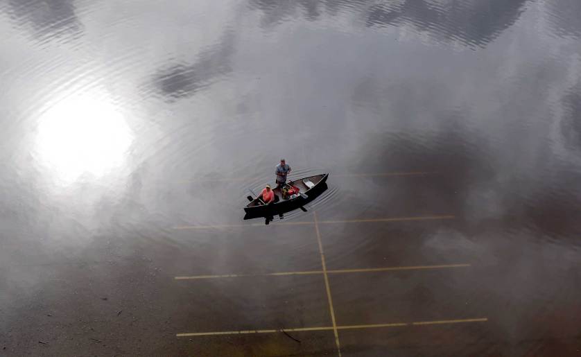 In this aerial photo, people prepare to launch a canoe from a flooded parking lot near Bear Creek Park Saturday, May 30, 2015, in Houston. The Colorado River in Wharton and the Brazos and San Jacinto rivers near Houston are the main focus of concern as floodwaters moved from North and Central Texas downstream toward the Gulf of Mexico. (AP Photo/David J. Phillip)