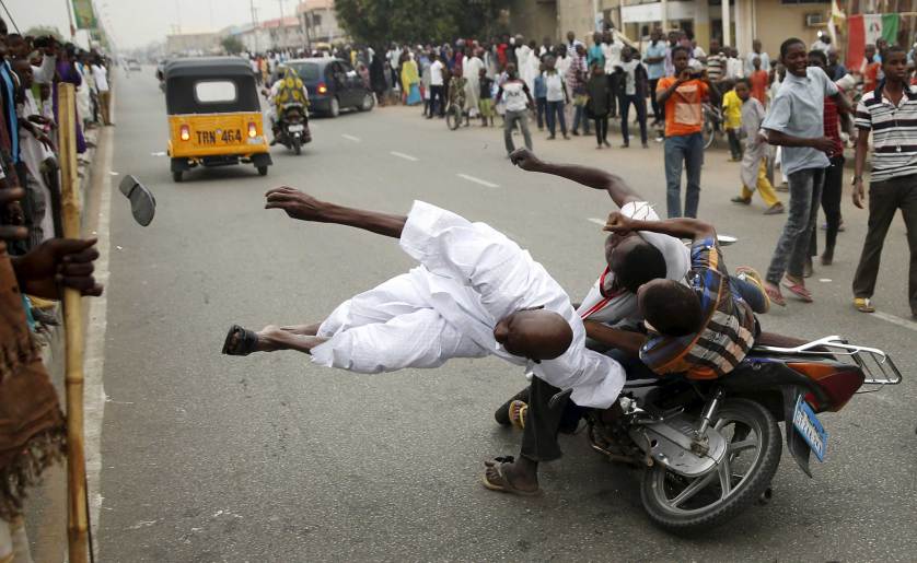 Supporters of the presidential candidate Muhammadu Buhari and his All Progressive Congress hits another supporter with a motorbike during celebrations in Kano March 31, 2015. Nigeria's opposition APC declared an election victory on Tuesday for former military ruler Buhari and said Africa's most populous nation was witnessing history with its first democratic transfer of power. REUTERS/Goran Tomasevic TPX IMAGES OF THE DAY - RTR4VMW2