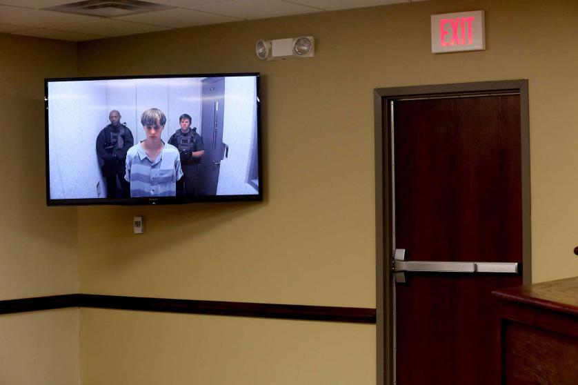 epa04809298 Suspect Dylann Roof (C) appears via video link at a bond hearing in court in North Charleston, South Carolina, USA, 19 June 2015. He is charged with nine counts of murder and firearms charges in the shooting deaths on 17 June at Emanuel African Methodist Episcopal Church in downtown Charleston. EPA/Grace Beahm / POOL