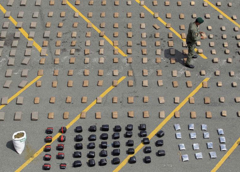 A Colombian police officer carries a pack of marijuana seized in Cali March 30, 2015. Colombian narcotics police seized 4.1 tons of marijuana from drug trafficking gangs in two houses in Corinto, Cauca, according to authorities. REUTERS/Jaime Saldarriaga TPX IMAGES OF THE DAY