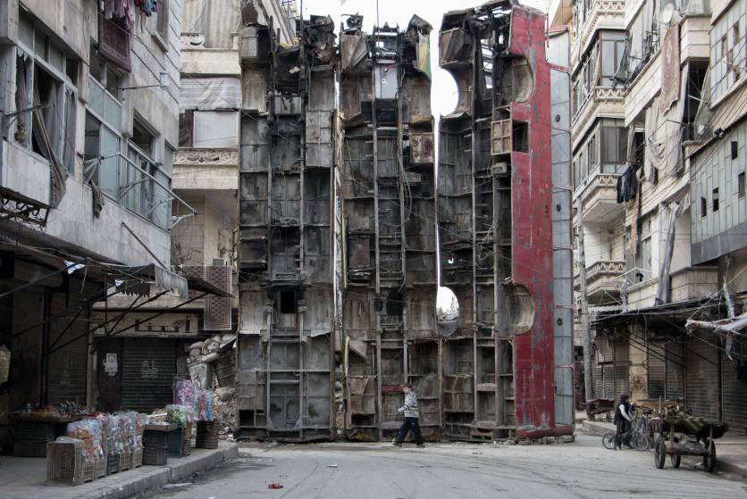 A young boy walks past a makeshift barricade made of wreckages of buses to obstruct the view of regime snipers and to keep people safe, on March 14, 2015 in the rebel-held side of the northern Syrian city of Aleppo. Syria's conflict enters its fifth year on March 15, 2015 with the regime emboldened by shifting international attention and a growing humanitarian crisis exacerbated by the rise of the Islamic State group. AFP PHOTO / KARAM AL-MASRIKARAM AL-MASRI/AFP/Getty Images