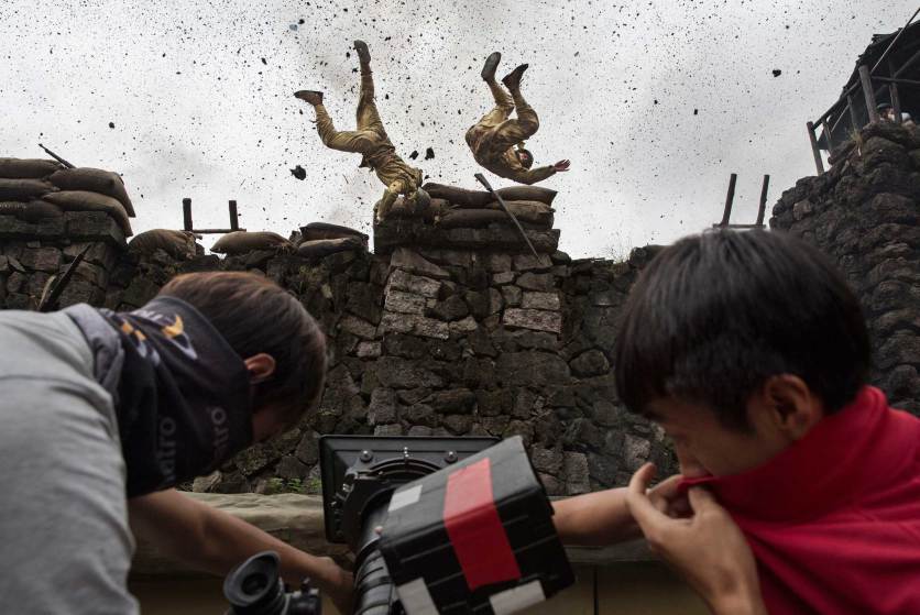 FANGYAN, CHINA - AUGUST 13: (CHINA OUT) Chinese actors playing Japanese soldiers are blown off a wall in an explosion during the filming of the series "The Last Noble," set during the second Sino-Japanese War on August 13, 2015 in Fangyan, China. Seventy years after the end of World War II, there is still widespread resentment across China toward Japan and its wartime misdeeds. It is estimated that hundreds of films depicting China's victory over Japan in 1945 are produced on the mainland every year and the genre remains one of the country's most popular entertainment draws. The conflict and what critics say is a refusal by most Japanese leaders to fully apologize for history, has long set the tone for strained relations between the two countries and and at times fuelled regional tension. Many of the films are shot in and around Hengdian Studios, Asia's largest production facility. (Photo by Kevin Frayer/Getty Images)