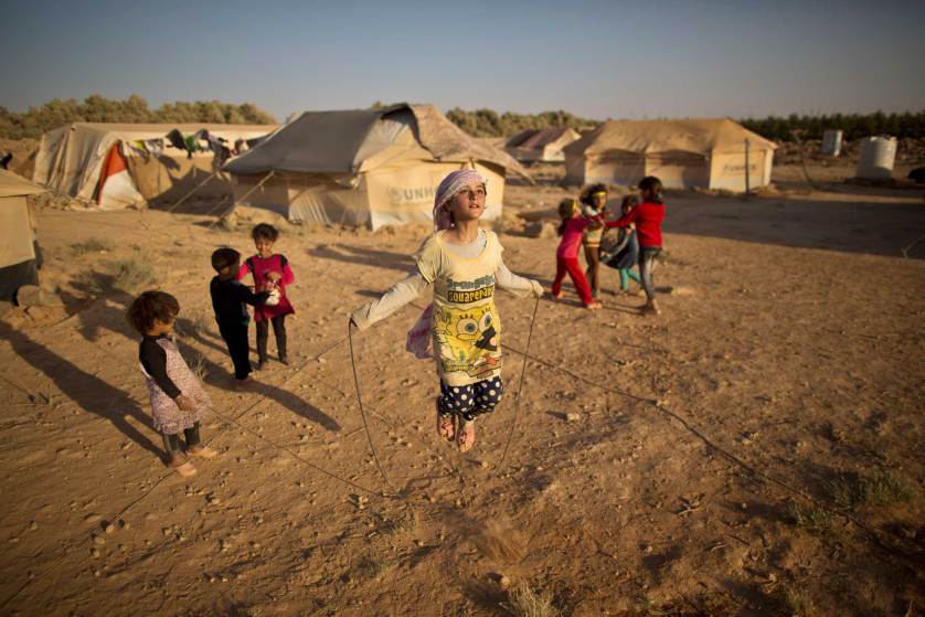 AP10ThingsToSee - Syrian refugee girl, Zubaida Faisal, 10, skips a rope while she and other children play near their tents at an informal tented settlement near the Syrian border on the outskirts of Mafraq, Jordan, Sunday, July 19, 2015. (AP Photo/Muhammed Muheisen)