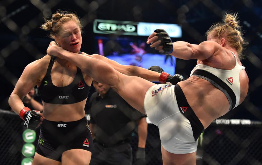 Holly Holm of the US (R) lands a kick to the neck to knock out compatriot Ronda Rousey and win the UFC title fight in Melbourne on November 15, 2015. RESTRICTED TO EDITORIAL USE NO ADVERTISING USE NO PROMOTIONAL USE NO MERCHANDISING USE. AFP PHOTO/Paul CROCK (Photo credit should read PAUL CROCK/AFP/Getty Images)