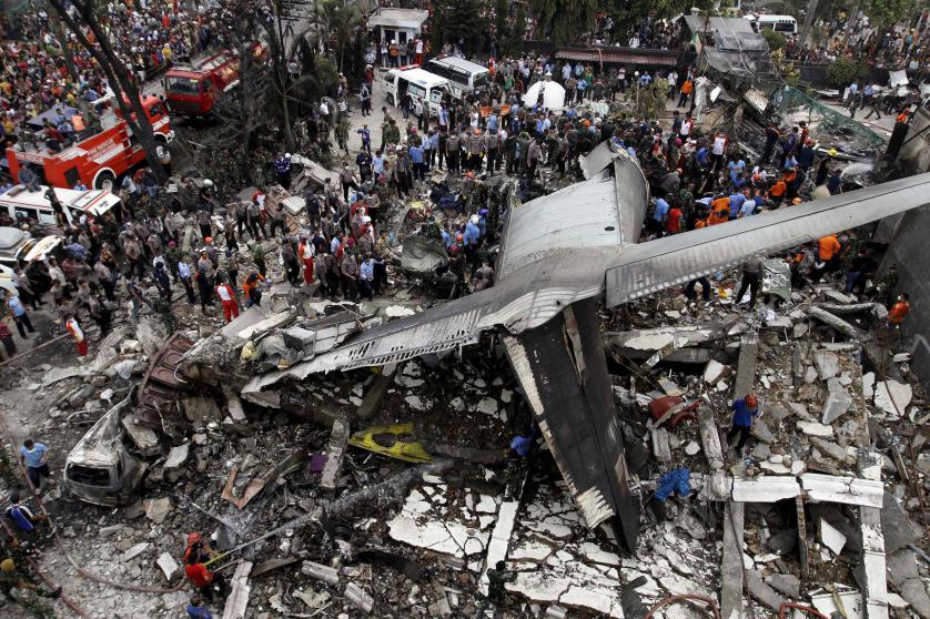 Security forces and rescue teams examine the wreckage of an Indonesian military C-130 Hercules transport plane after it crashed into a residential area in the North Sumatra city of Medan, Indonesia, June 30, 2015. At least 30 people were killed when the military transport plane crashed into a residential area two minutes after take-off in northern Indonesia on Tuesday, putting a fresh spotlight on the country's woeful air safety record. REUTERS/Roni Bintang TPX IMAGES OF THE DAY