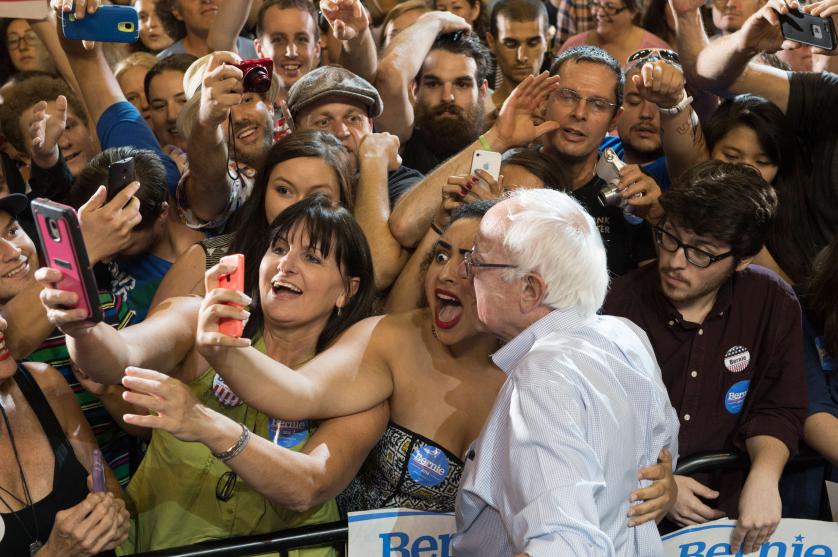 Naomi Scott, center, of McMinnville, Ore., takes a picture with Democratic presidential candidate Sen. Bernie Sanders, I-Vt., at a rally, Sunday, Aug. 9, 2015, at the Moda Center in Portland, Ore. (AP Photo/Troy Wayrynen)