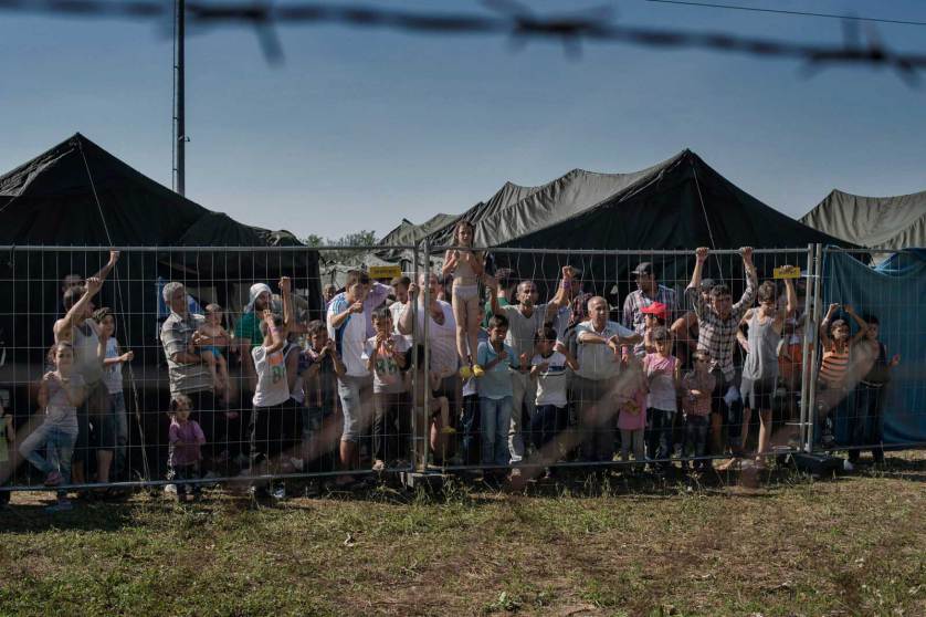 ROSZKE, Hungary August 29 2015 A group of migrants waits at a makeshift detention camp for Hungarian authorities to register their arrival in the European Union.